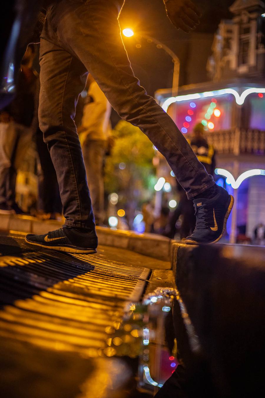Person in Nike trainers stepping down a street at night
