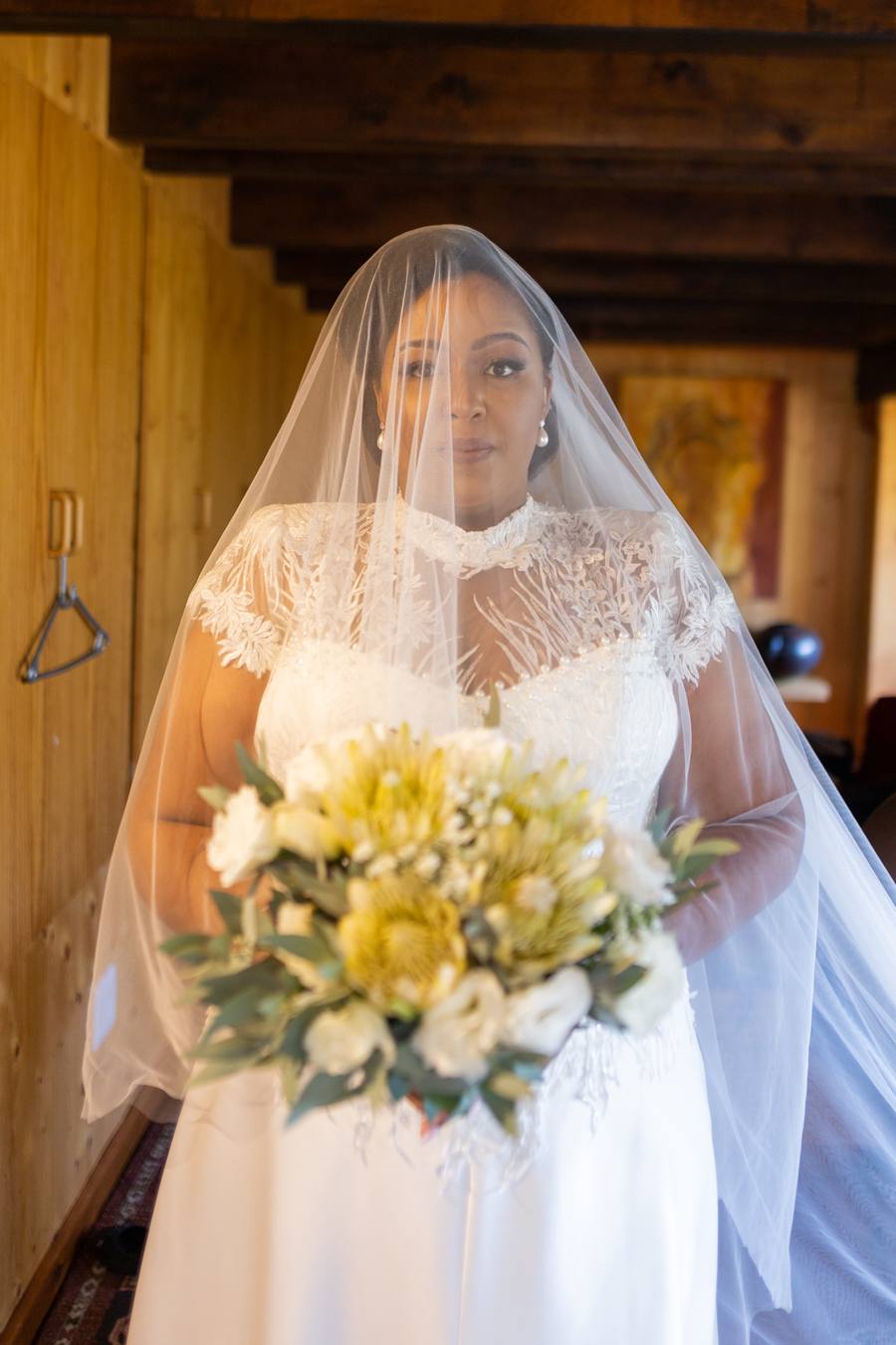 Bride in white dress and veil holding a bouquet of flowers