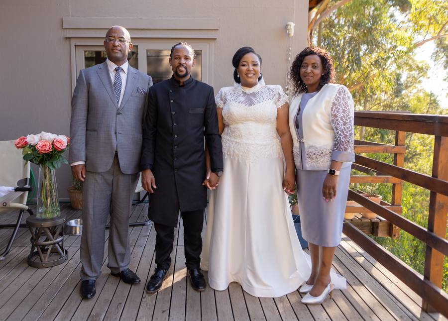 A family of four standing on a wooden deck, smiling for the camera