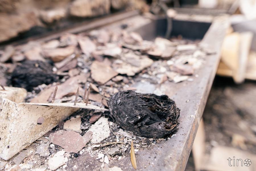 Charred remains of a wooden structure on a stone ledge