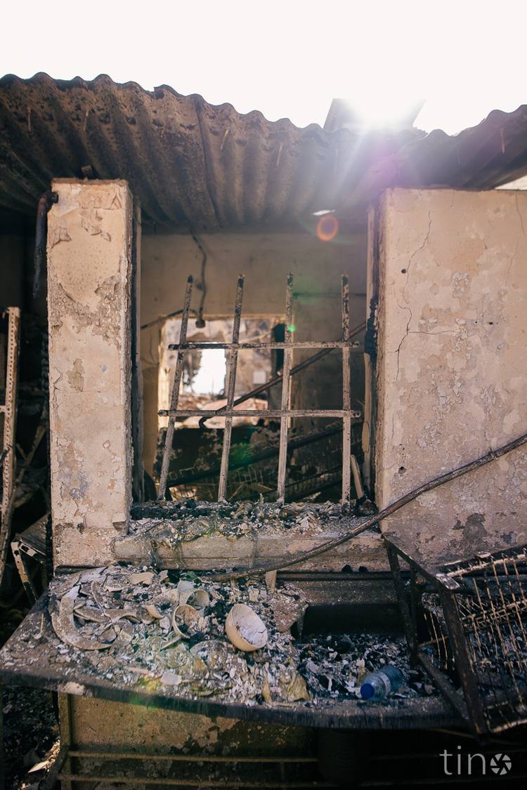 Burned out building with broken window and debris on floor
