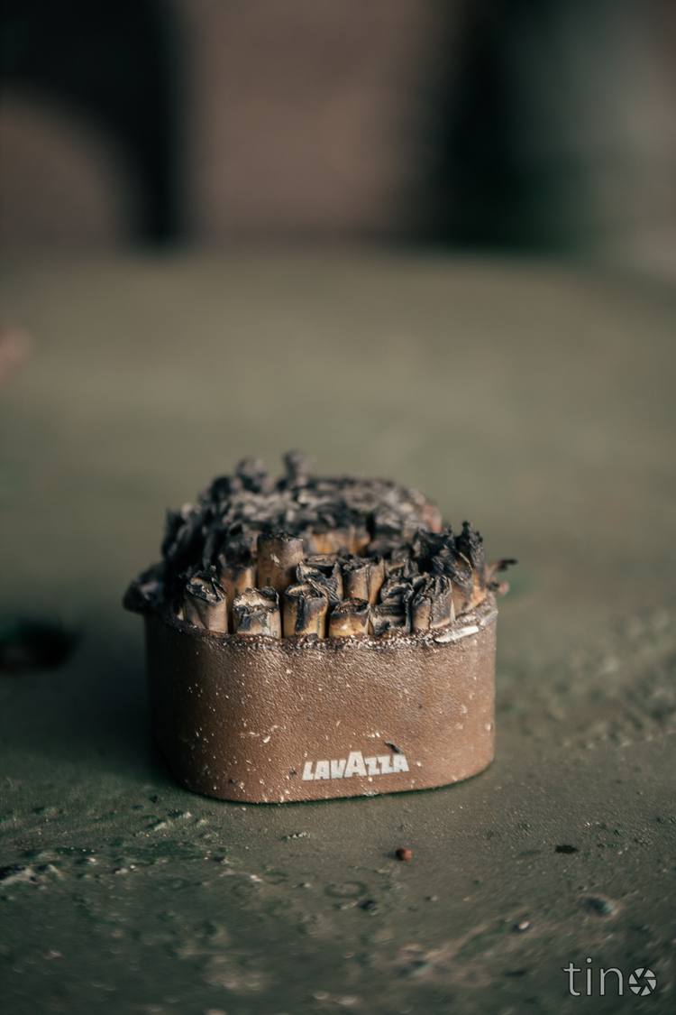 Burnt matchbox on a green surface with blurred background