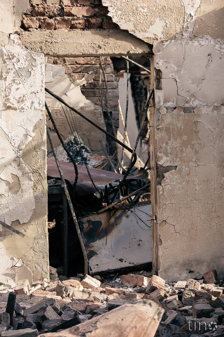 Ruined building with broken walls and debris on the ground