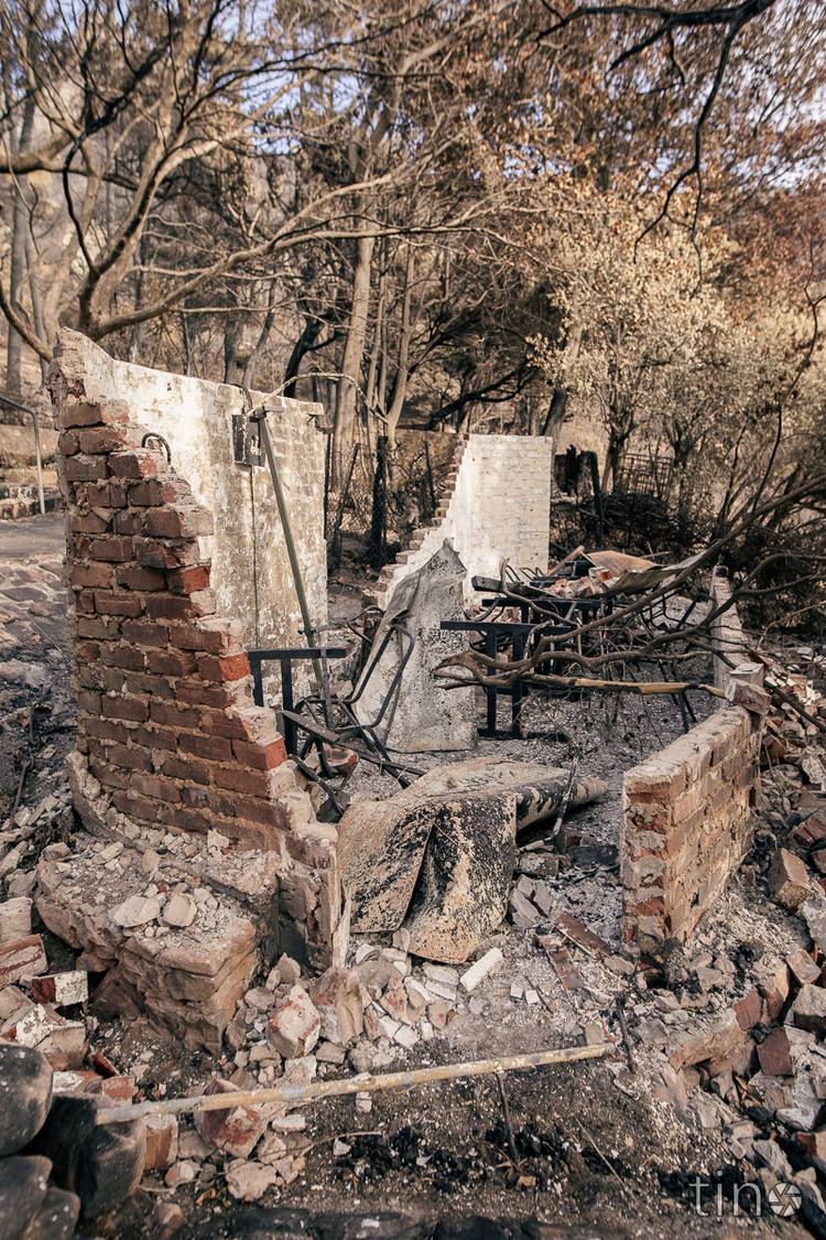 Ruined brick structure with charred remains and debris in a forest