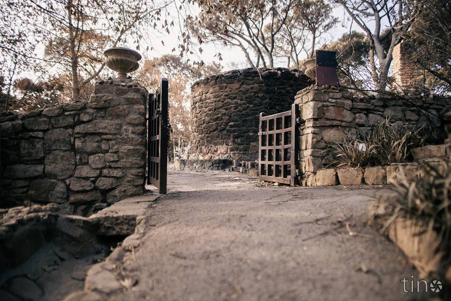 Stone pathway leading to Rhodes Memorial ruins with trees and stone walls