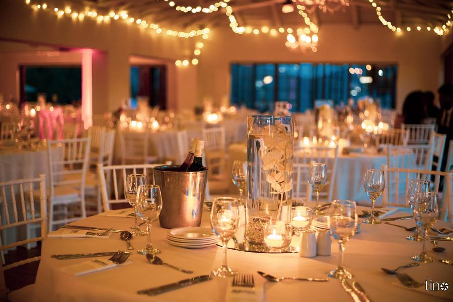 A table set for a formal dinner with candles, flowers, and wine glasses.