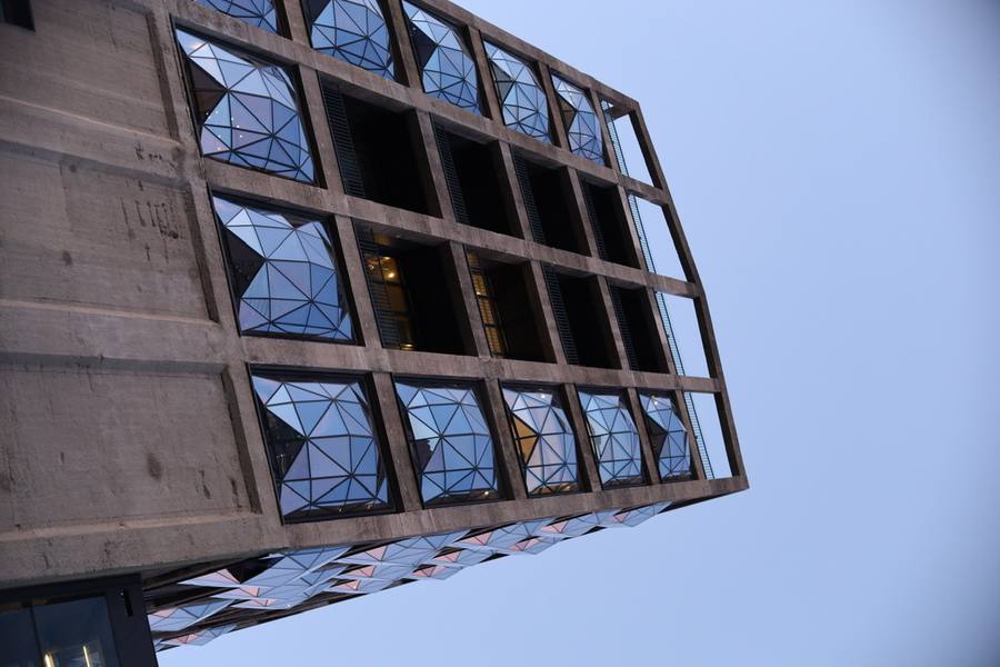 A modern building with geometric glass windows and a concrete exterior